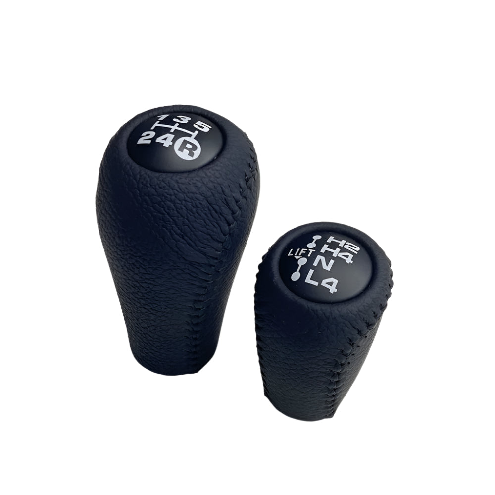 Two black gear shift knobs with engraved numbers on a white background