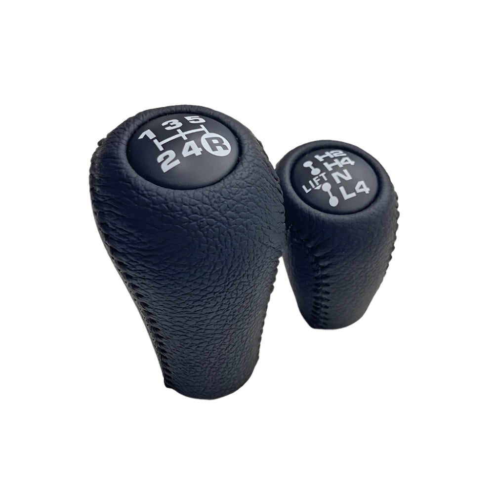 Two black gear shift knobs on a white background