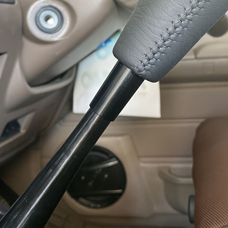 Close-up of a car gear shift with a gray cover inside a vehicle.