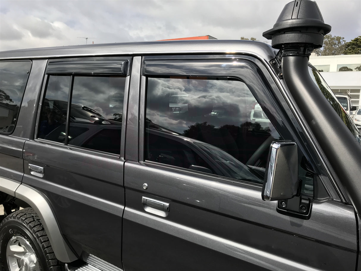 Side view of a gray SUV with a cloudy sky in the background